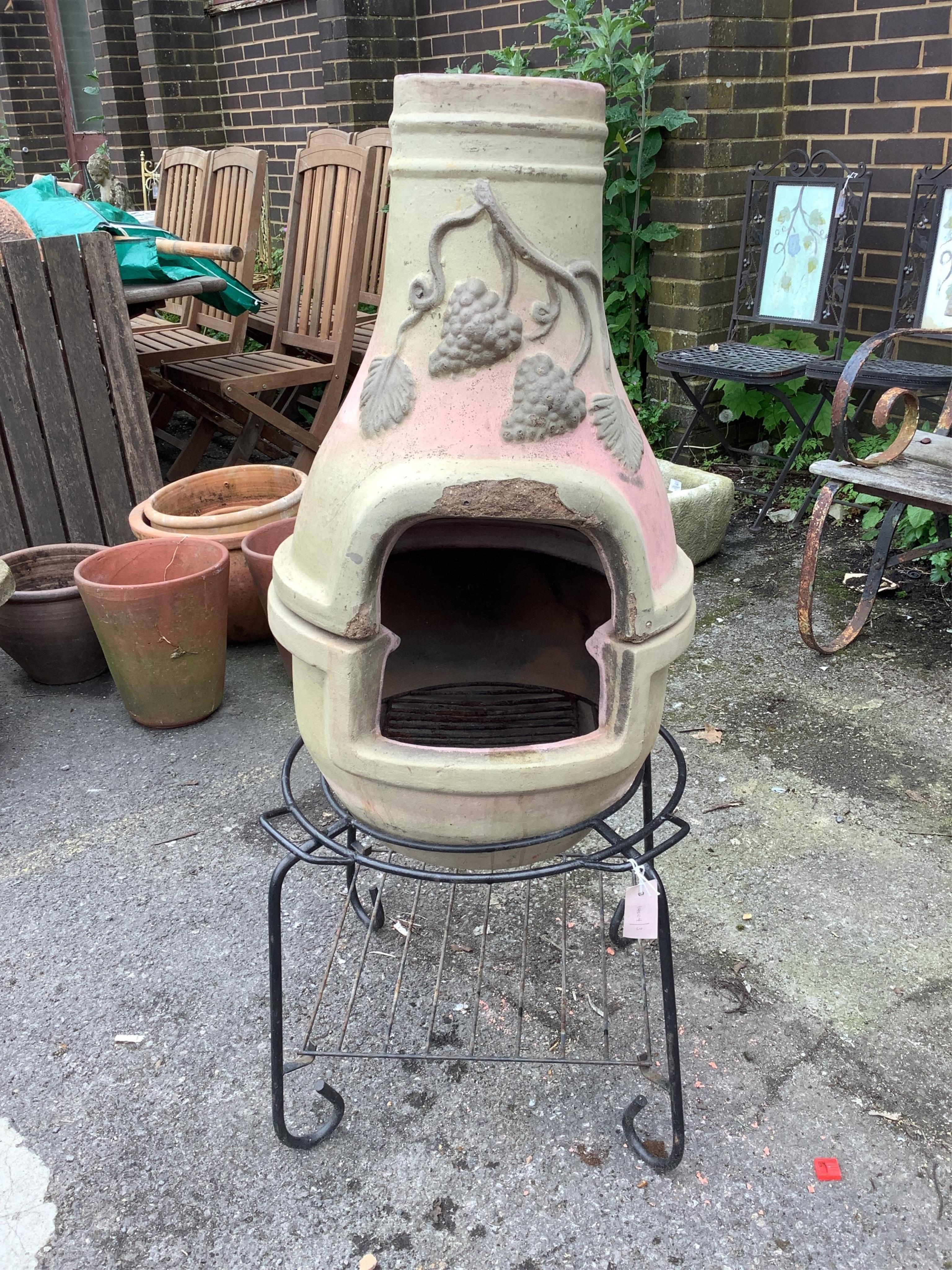 A terracotta sectional chiminea on wrought iron stand, height 115cm